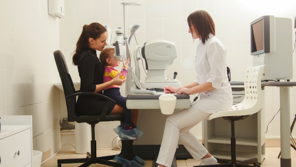 Criança fazendo um exame no consultório de uma oftalmologista.