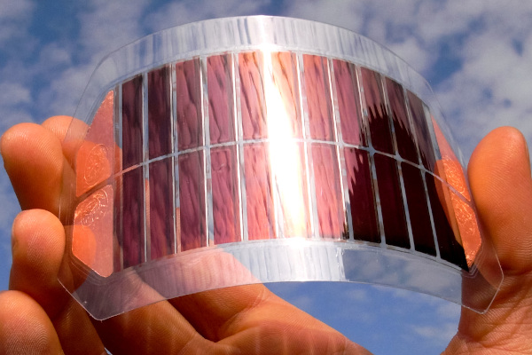  Pessoa segurando uma célula solar de rutênio em direção ao céu.