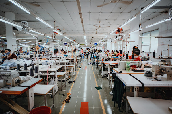 Pessoas trabalhando em uma fábrica de roupas no Vietnã.