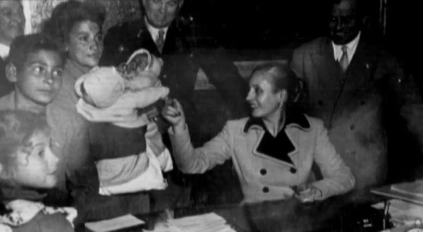 Eva Perón brincado com os filhos de uma senhora que ela recebeu na Casa Rosada, o palácio presidencial argentino.