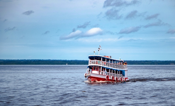 Barco navegando em um rio na Amazônia.