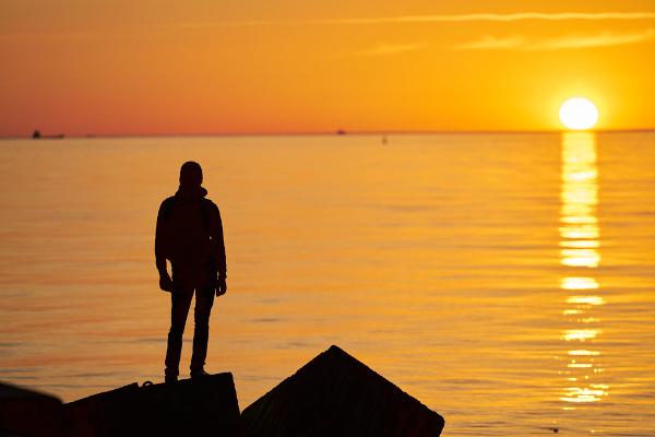 Silhueta de uma sessão de homem com tão triste por do sol.