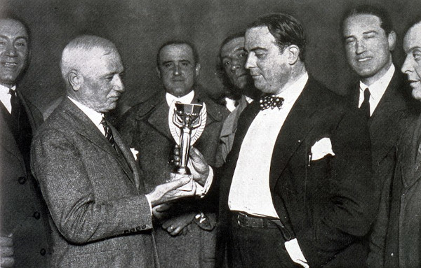 A foto em preto e branco mostra o francês Jules Rimet, a taça com seu nome e Raúl Jude.