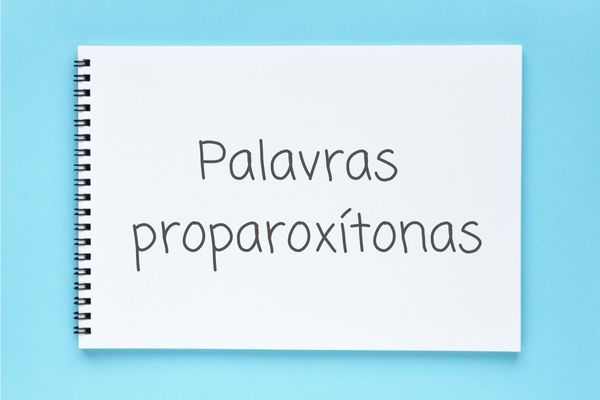 Caderno com o escrito “palavras proparoxítonas” sobre uma superfície plana de cor azul.