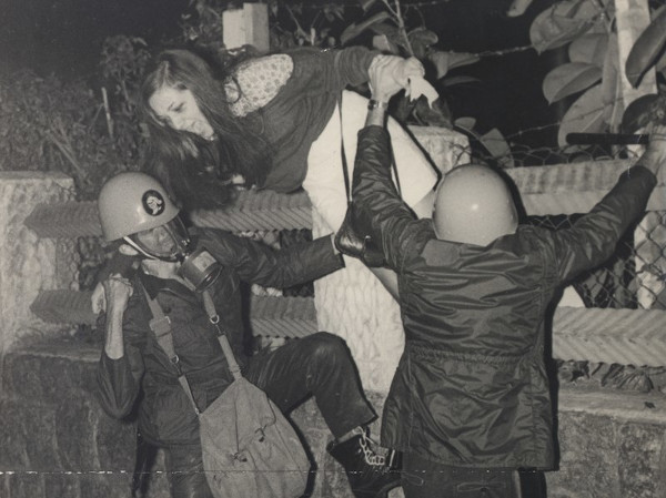 Mulher sendo presa por policiais durante a ditadura, período em que foram cometidos crimes contra a humanidade.