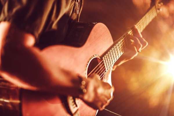 Homem tocando violão, um instrumento de cinco cordas comum no sertanejo.