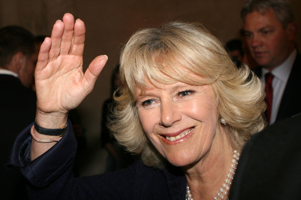 Camilla Parker, atual rainha consorte do Reino Unido, acena com a mão direita.