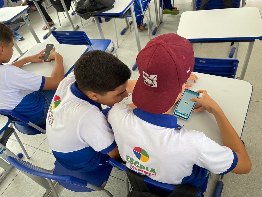 Dois jovens estudantes jogam game no smartphone 