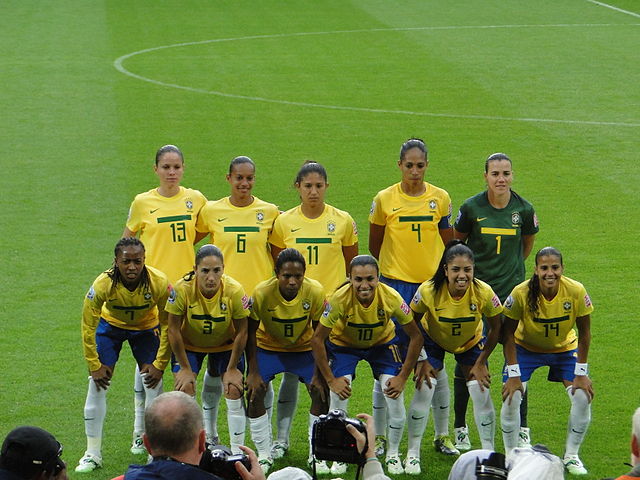 Atletas da seleção brasileira feminina de futebol posando para foto no campo