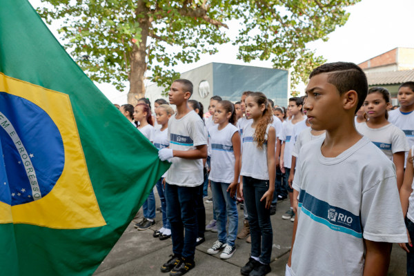 Crianças em escola cantando o Hino Nacional Brasileiro.