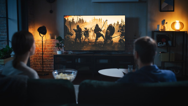 Pessoas assistindo a filme de guerra, uma forma de aprender História nas férias.