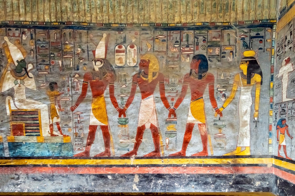 Osíris sentado em seu trono, Hórus e outras figuras em uma pintura egípcia.