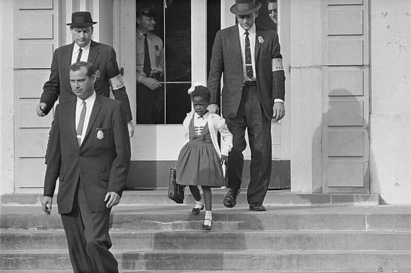 Ruby Bridges, uma das mulheres negras inspiradoras, sendo levada até a escola por agentes do FBI em 1960.