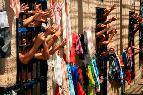 Braços de detentos em um presídio na Bahia, em alusão à origem do PCC.