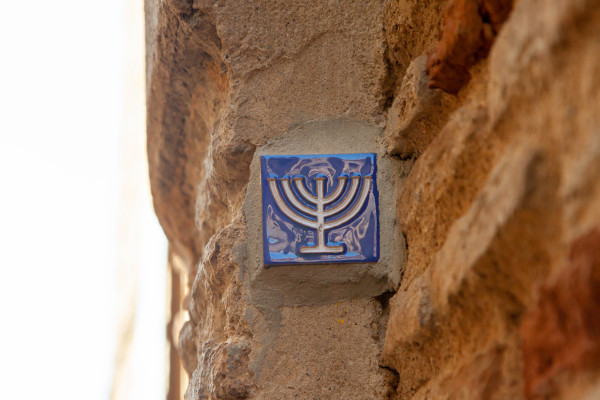 Menorá, um dos símbolos do judaísmo, em parede de uma edificação na Espanha, destino de muitos judeus com a diáspora judaica.