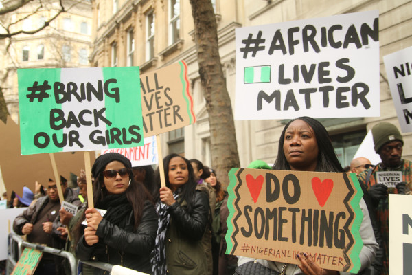 Mulheres segurando cartazes em protesto ao ataque do Boko Haram às 276 garotas sequestradas em 2014.