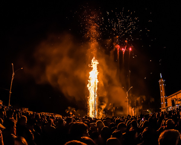 Multidão assistindo à queima da fogueira, um dos principais símbolos da Festa Junina.
