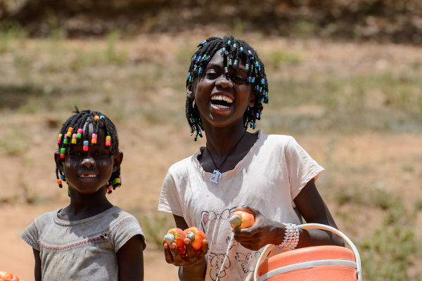 Crianças segurando cajus em Guiné-Bissau.