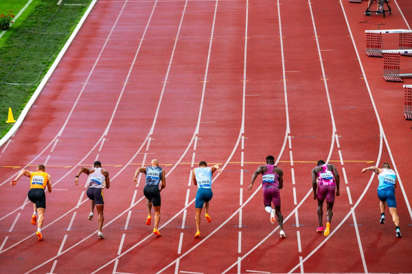  Atletas de corrida em campo de atletismo, uma das modalidades esportivas dos Jogos Olímpicos de Verão.