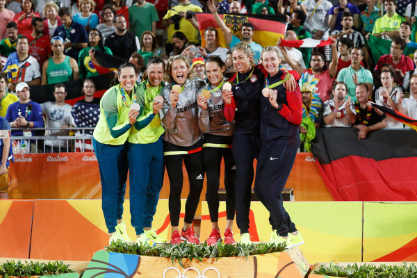 Atletas do vôlei de praia em pódio olímpico nos Jogos Olímpicos de Verão Rio 2016.