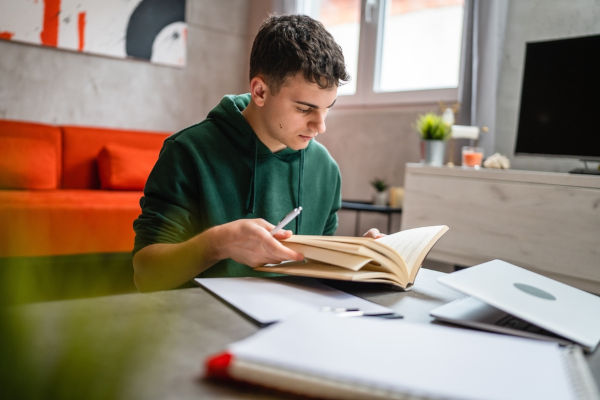 Jovem lendo livro, em alusão ao estudo da utilização do acento circunflexo.