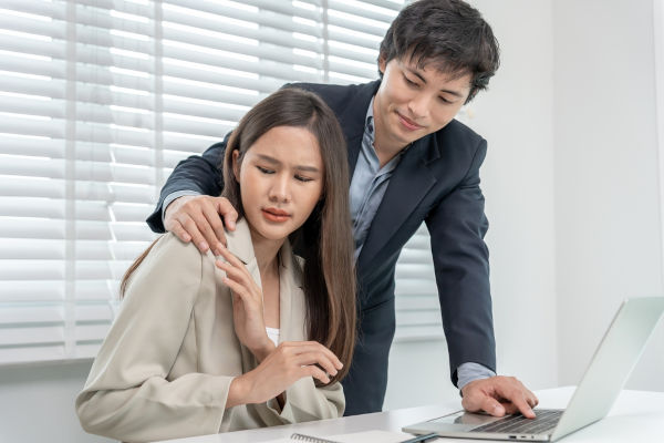 Mulher sendo vítima de assédio sexual no local de trabalho.