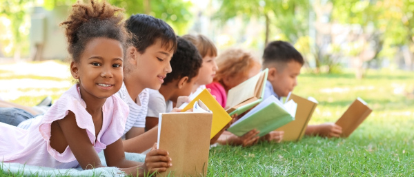 Crianças segurando obras de literatura infantil