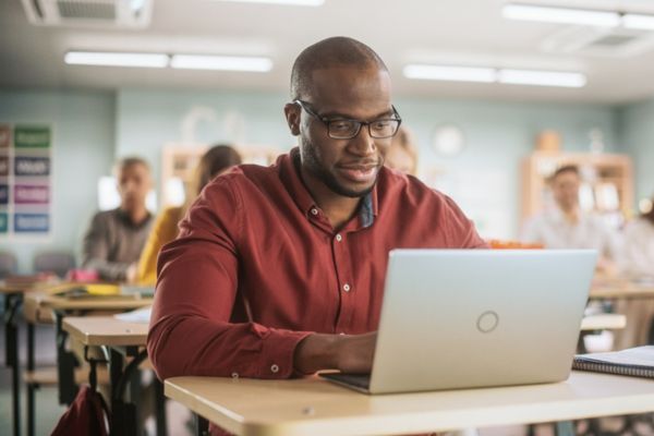 Homem adulto realiza prova em referência ao adiamento dos resultados do CNU.