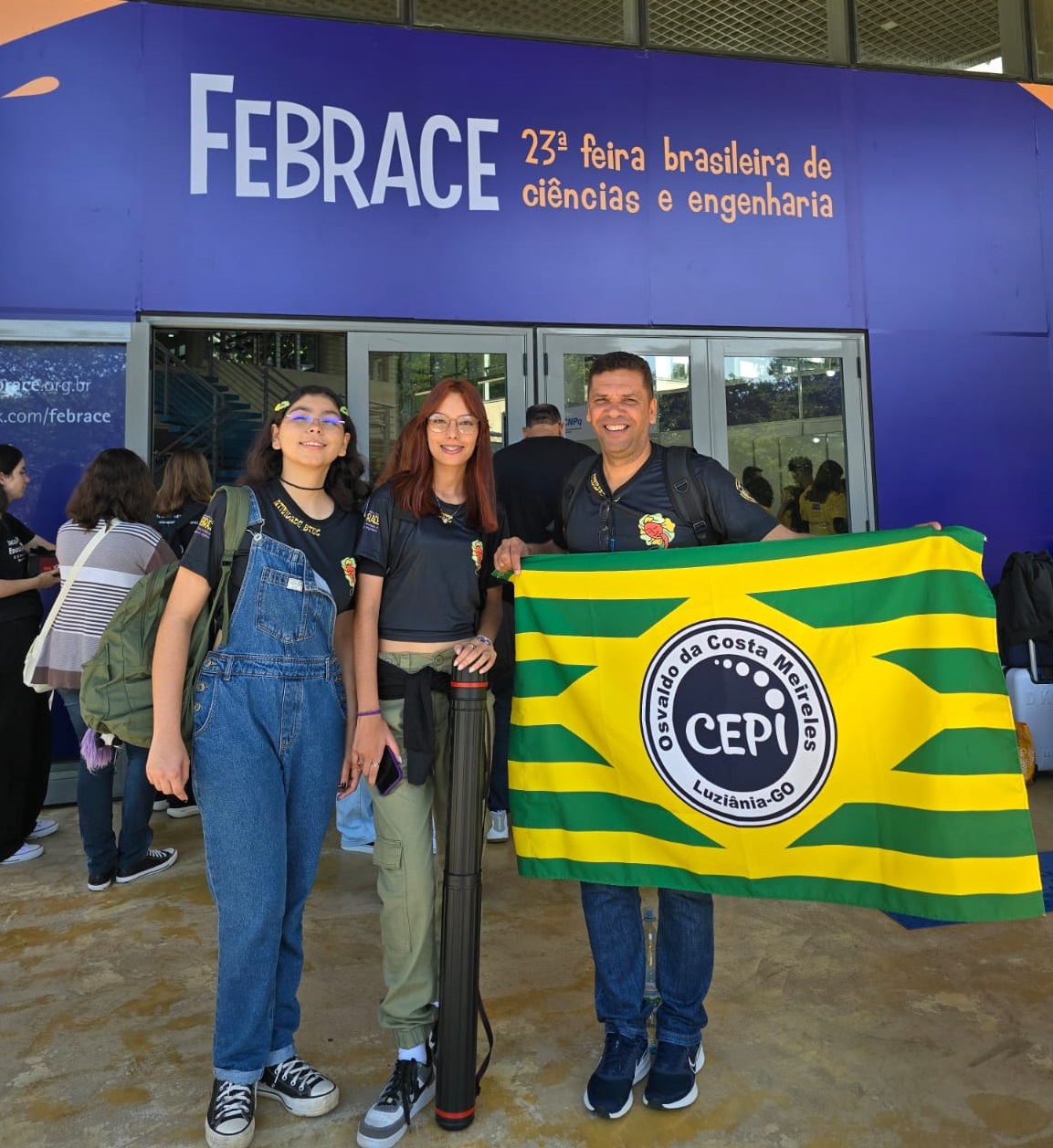 Alunas com bandeira do colégio em que estudam