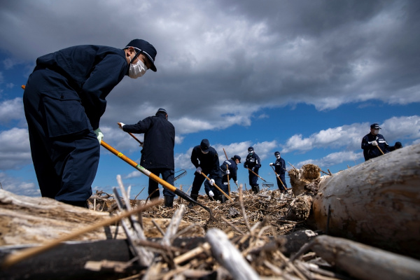Policiais procurando vestígios dos desaparecidos no acidente nuclear de Fukushima.