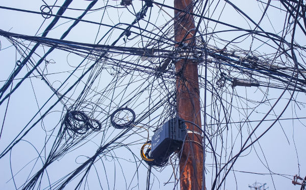 Poste com fios el&eacute;tricos emaranhados, um exemplo de polui&ccedil;&atilde;o visual. 