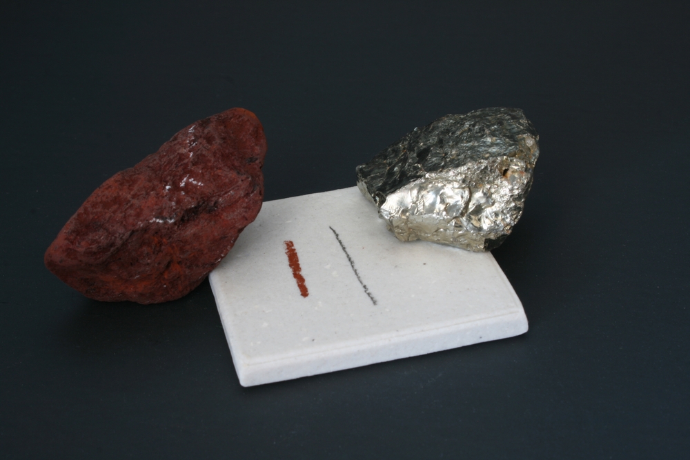 Dois riscos em uma superfície e dois minerais em texto sobre escala de Mohs.