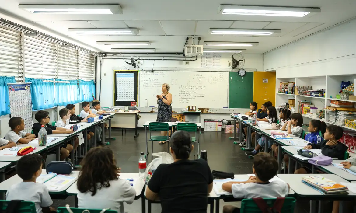 Professor em sala de aual com estudantes.