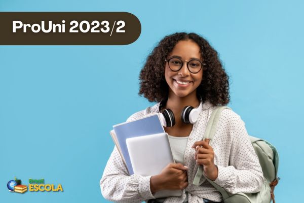 Estudante negra sorrindo se óculos, fundo azul. Texto ProUni 2023/2
