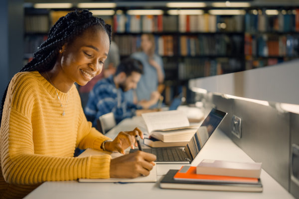 Estudante negra sorrindo estudando