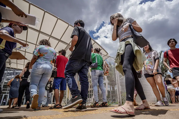 Estudante com cabelos longos olhando no computador. Na imagem, está escrito: reaplicação do Enem 2024